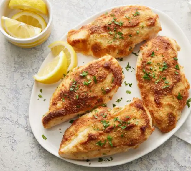 Chicken breasts being marinated in a flavorful mixture, a key step in cooking moist chicken breasts.
