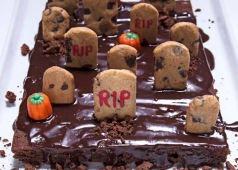 A tray of freshly baked graveyard brownies decorated with cookie tombstones and gummy worms.