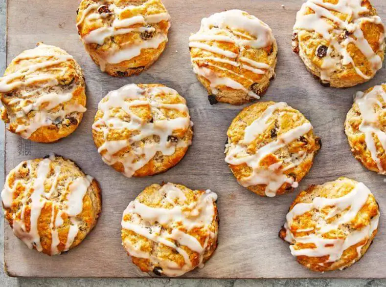 Freshly baked cinnamon raisin biscuits on a cooling rack, showcasing their golden-brown texture and plump raisins, perfect for a homemade treat.